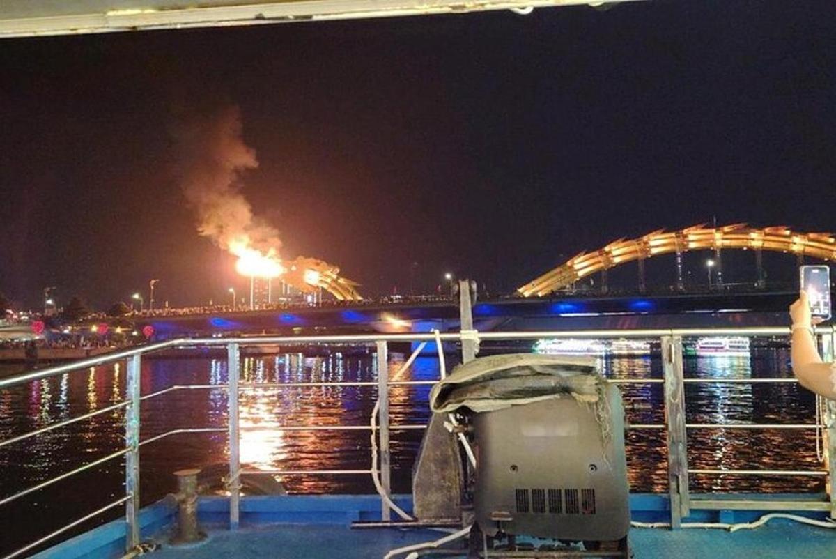 una persona fent una foto d'un incendi en un vaixell a la nit
