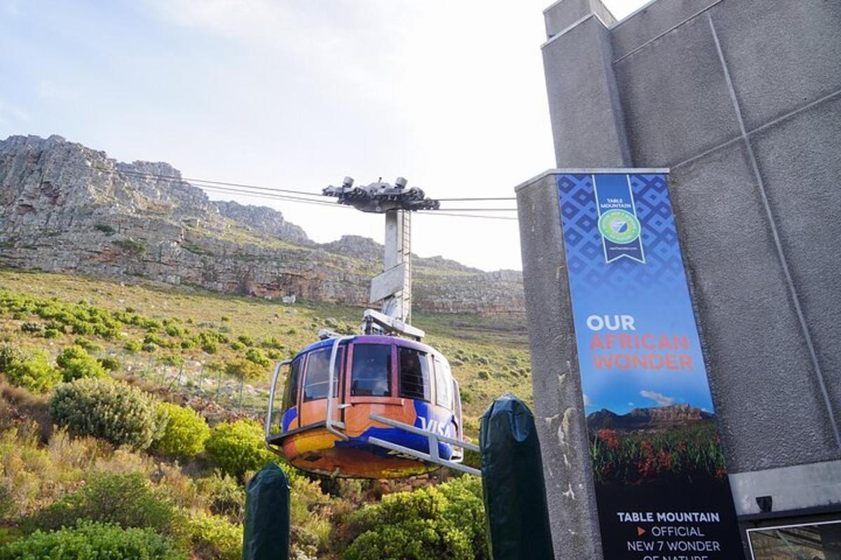 eine blau-orangefarbene Seilbahn, die über einen Hügel fliegt