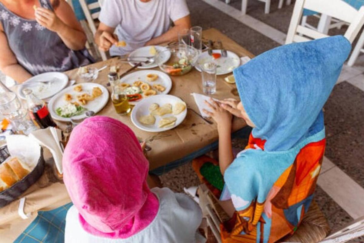 Un grupo de personas sentadas en una mesa comiendo comida