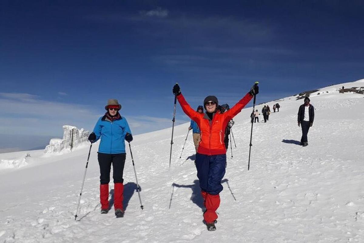 two people on a ski slope with their arms in the air