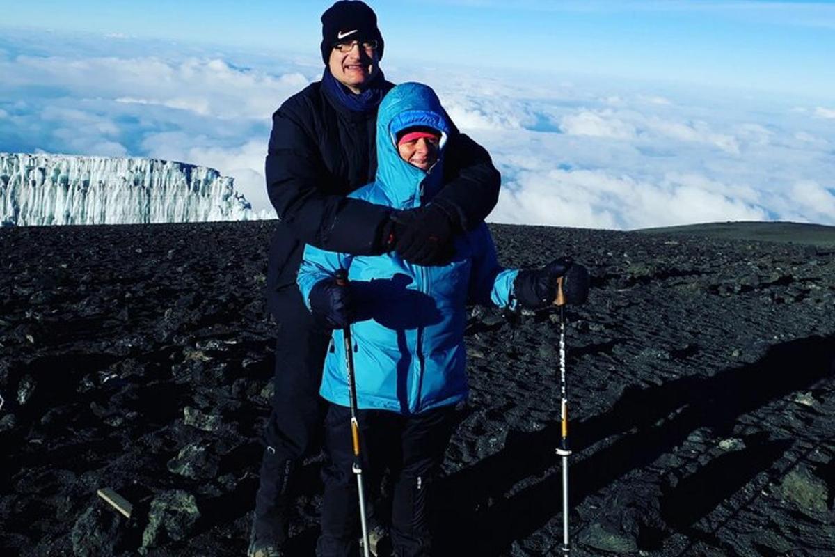 a man and woman standing on top of a mountain