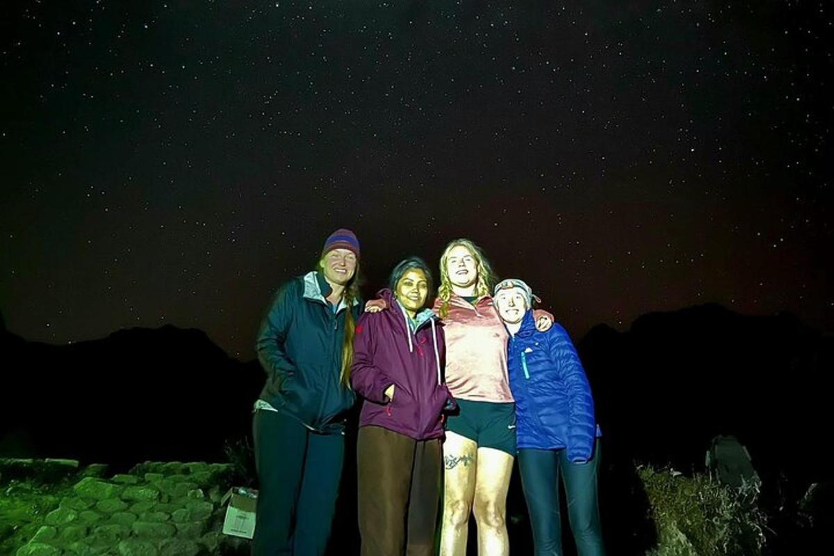 un gruppo di persone che posano per una foto di notte