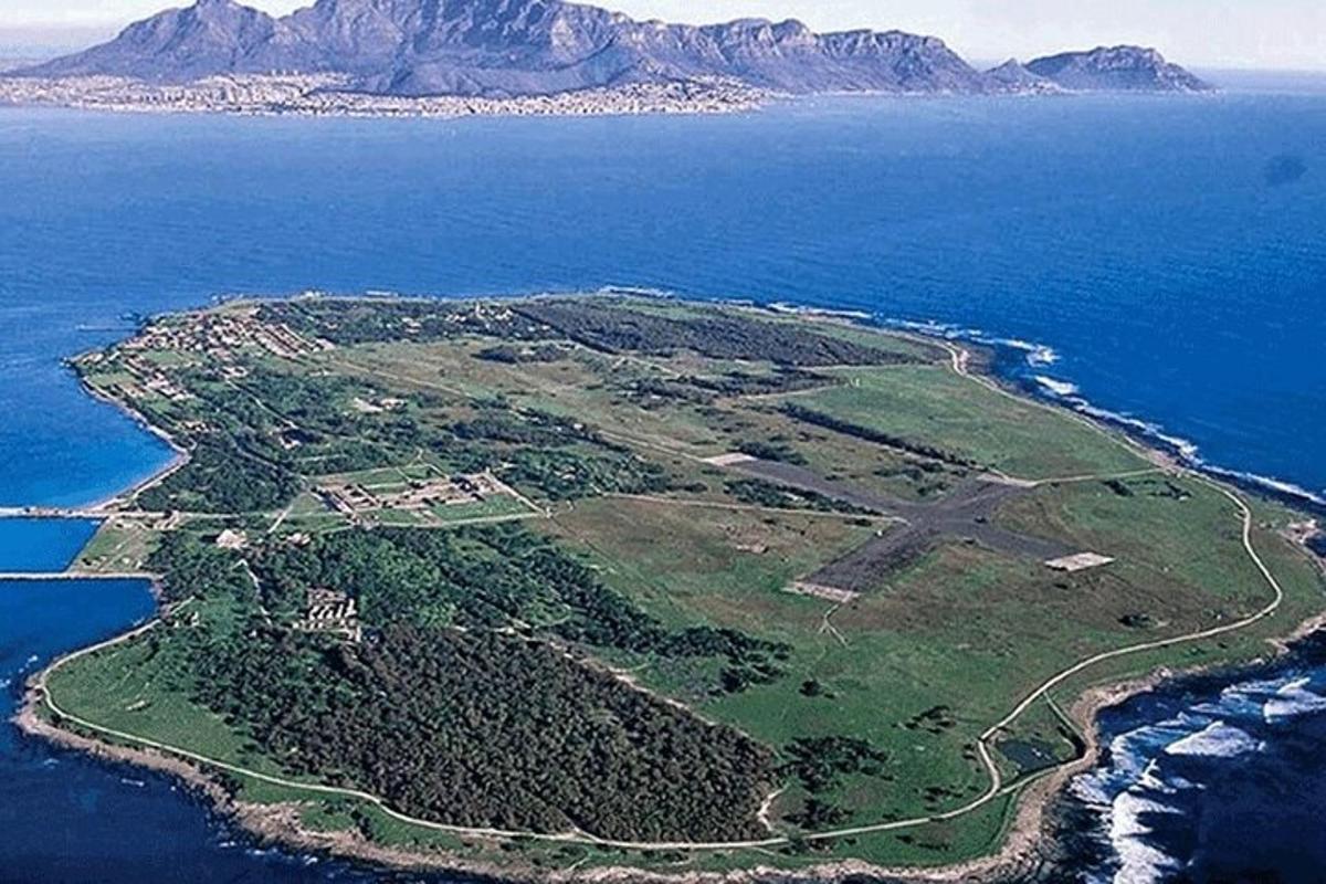 an island in the ocean with mountains in the background
