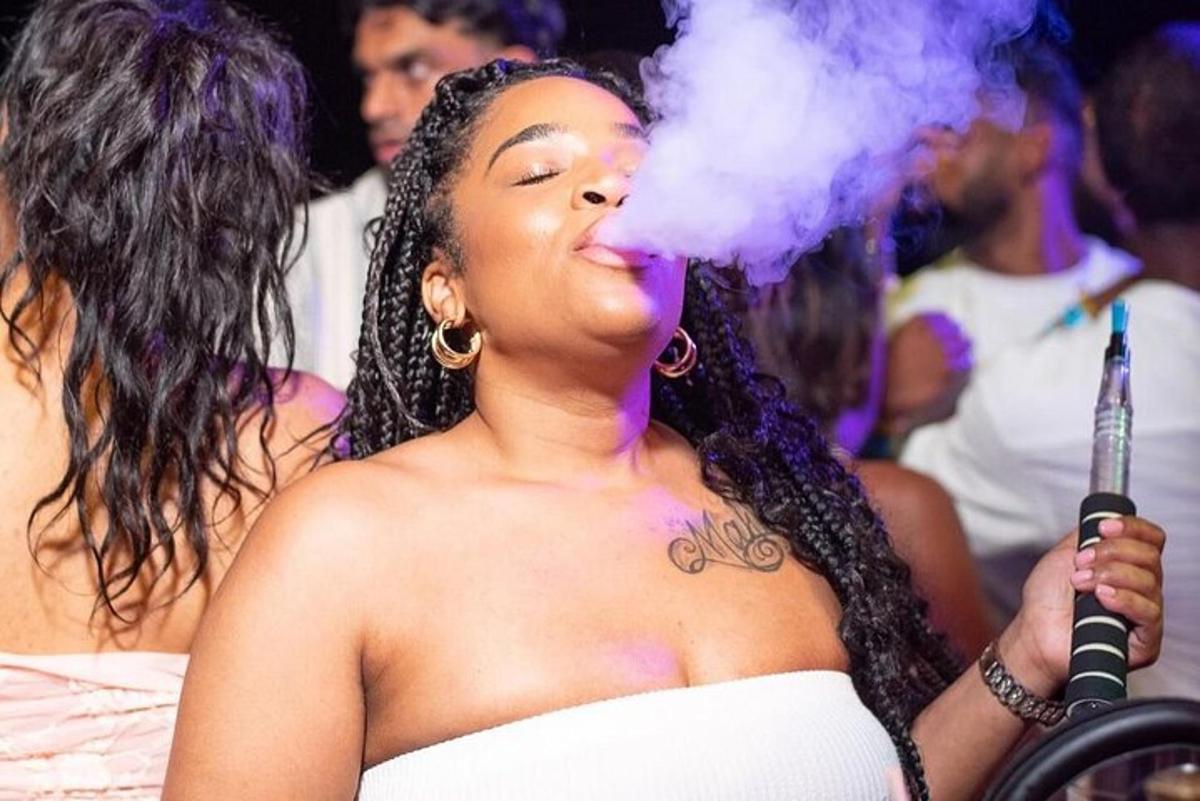 una donna tiene in mano un microfono e fuma