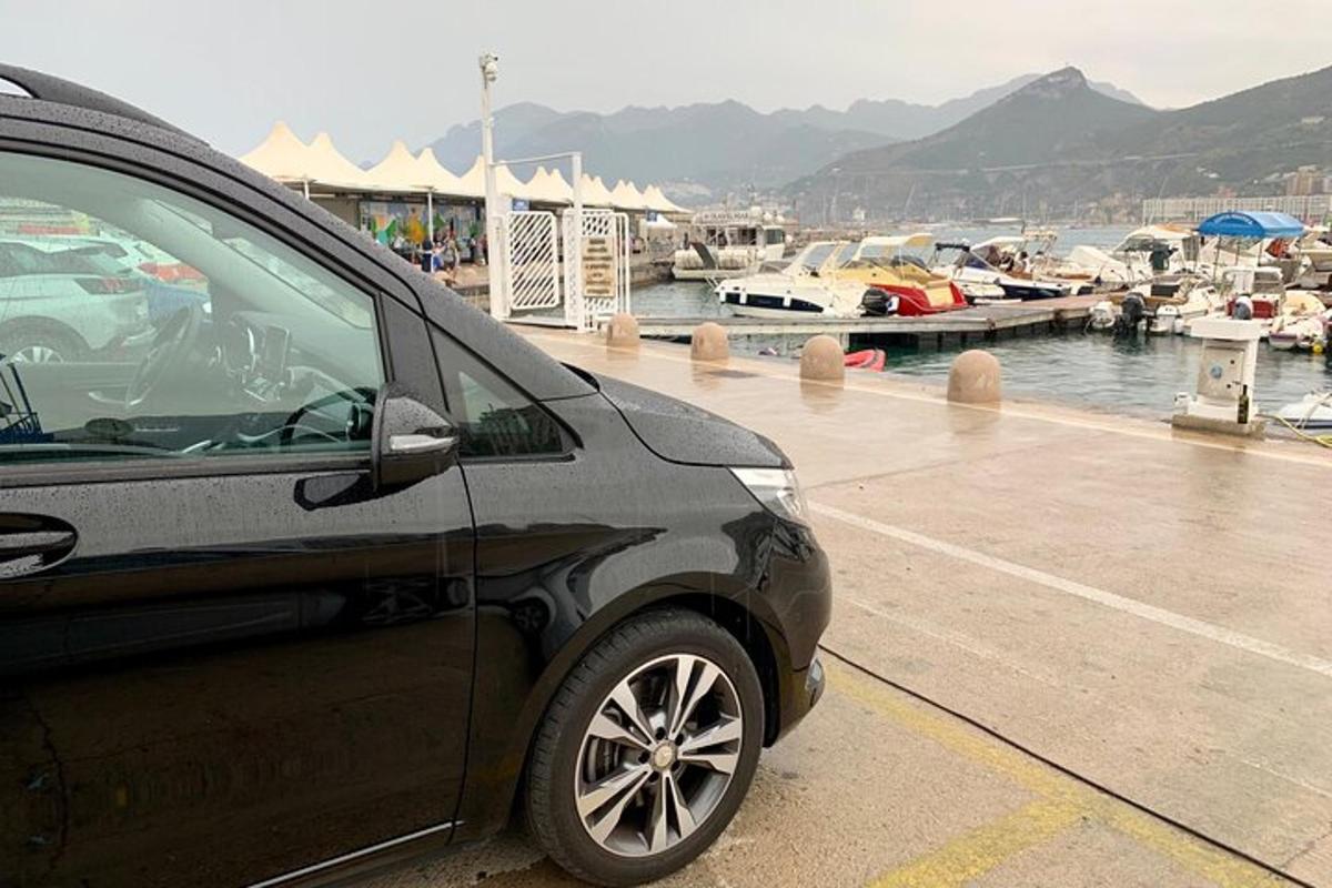 černé auto zaparkované vedle přístavu s loděmi