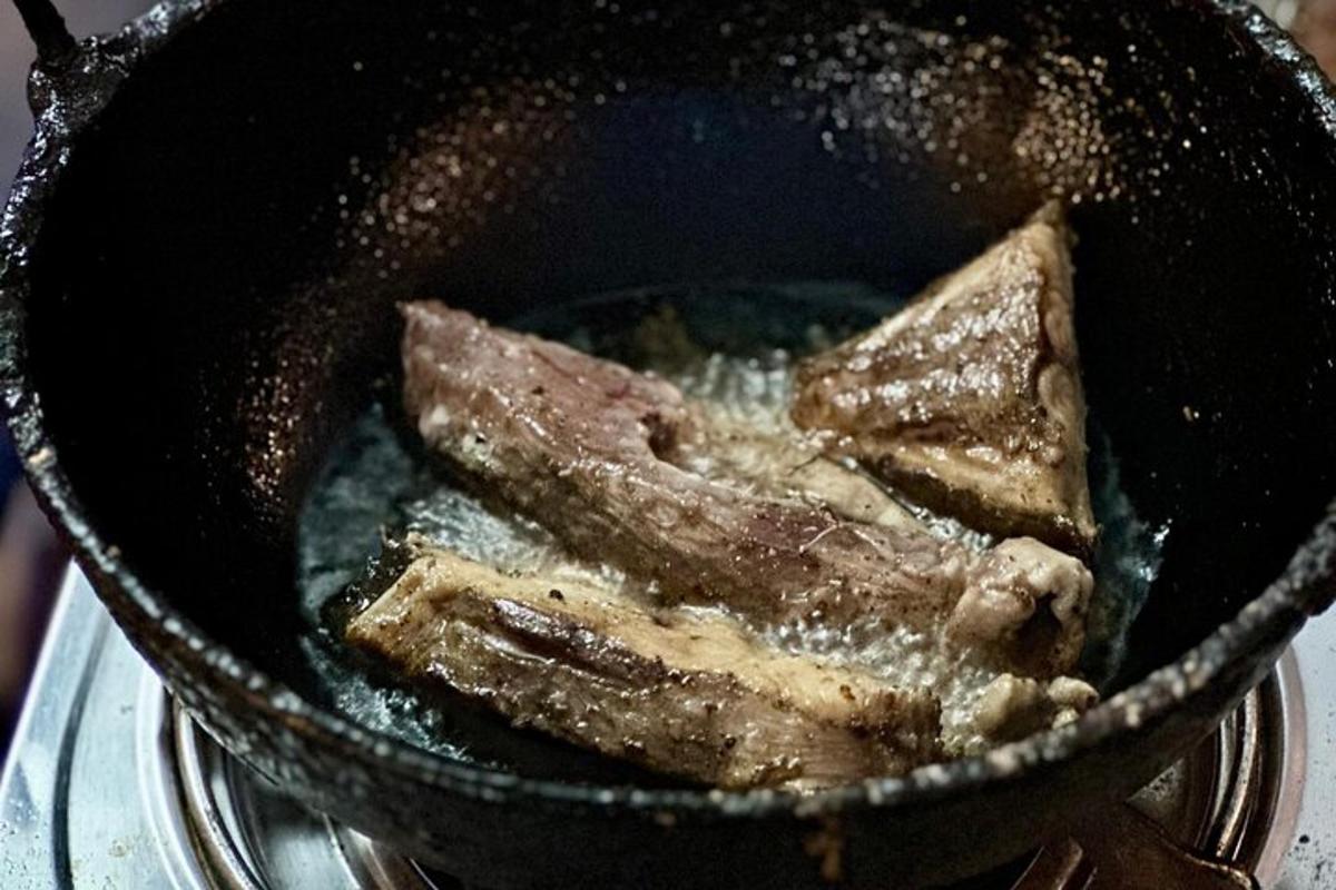 pönnu með kjöti sem er að steikjast í