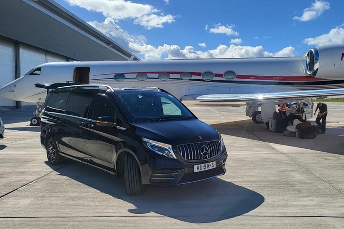 một chiếc xe SUV màu đen đang đỗ cạnh một chiếc máy bay
