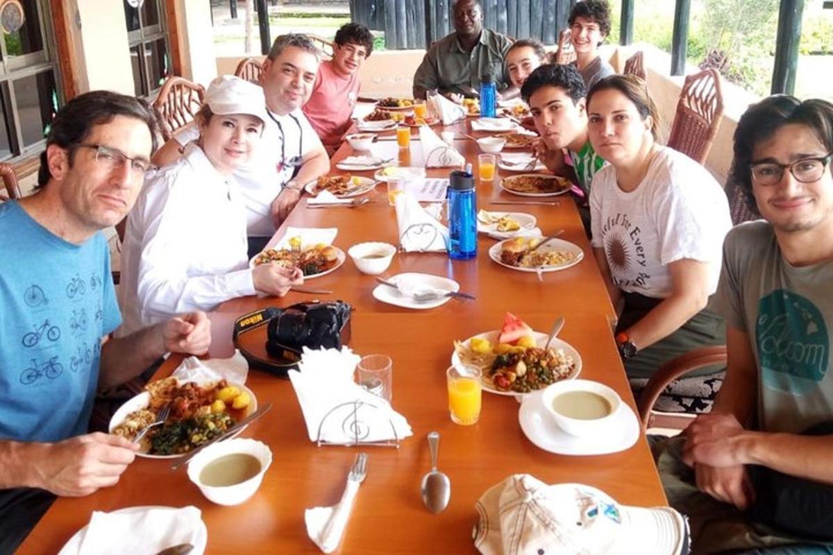 un gruppo di persone sedute a un tavolo che mangiano cibo
