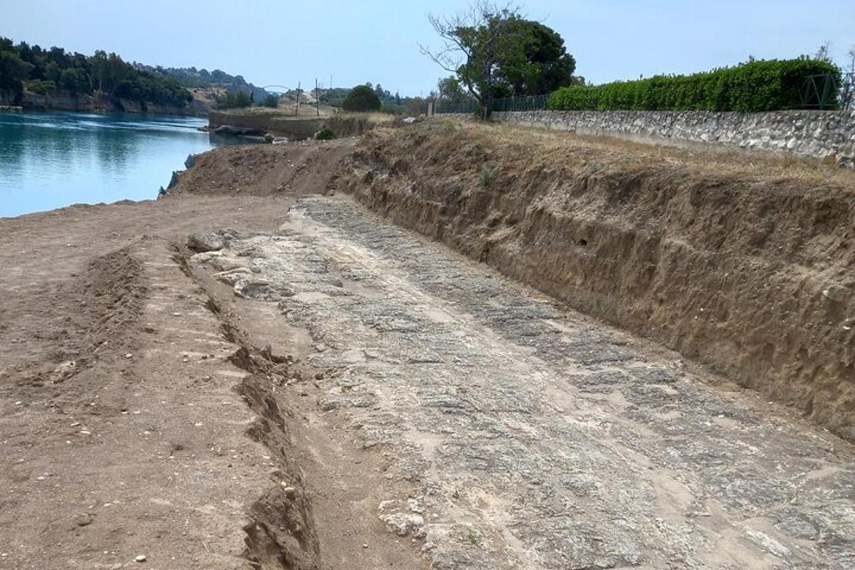 a dirt road next to a body of water