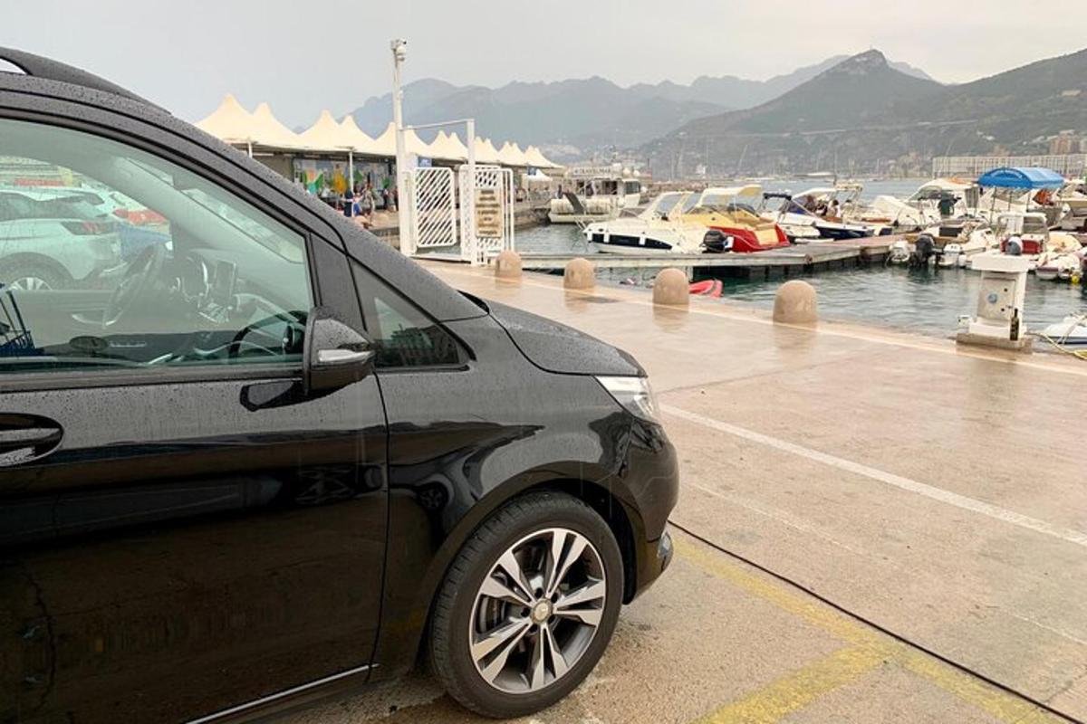 un'auto parcheggiata accanto a un porto turistico con barche