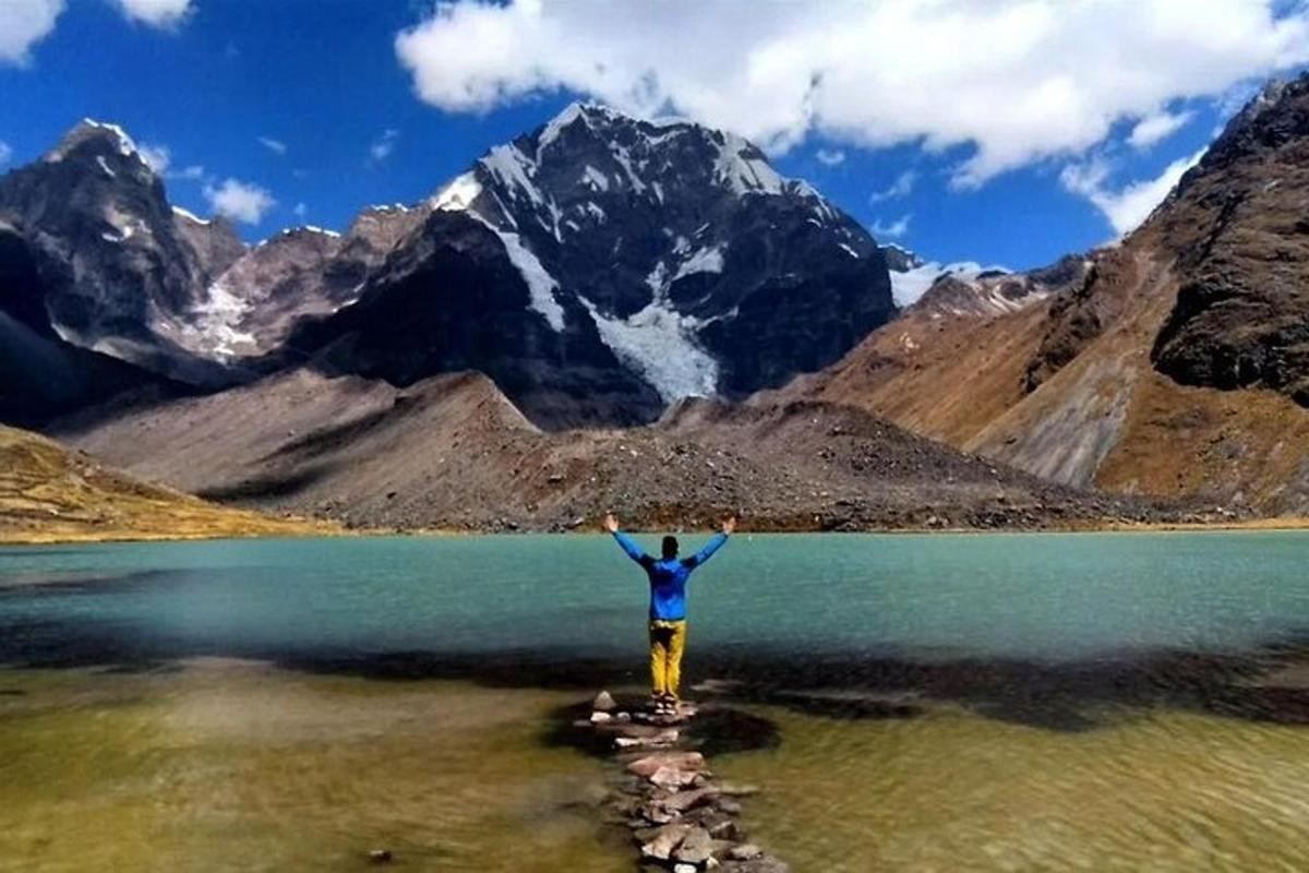 un uomo in piedi nell'acqua di fronte a una montagna