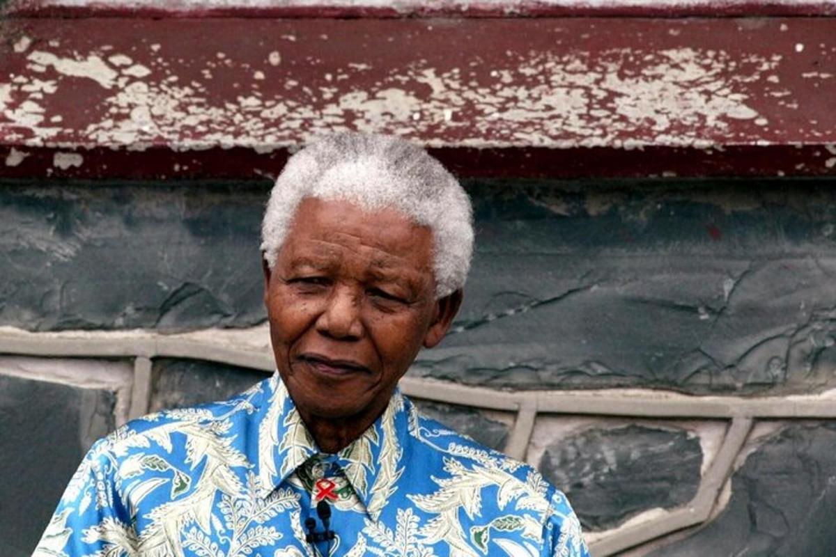an older man standing in front of a wall