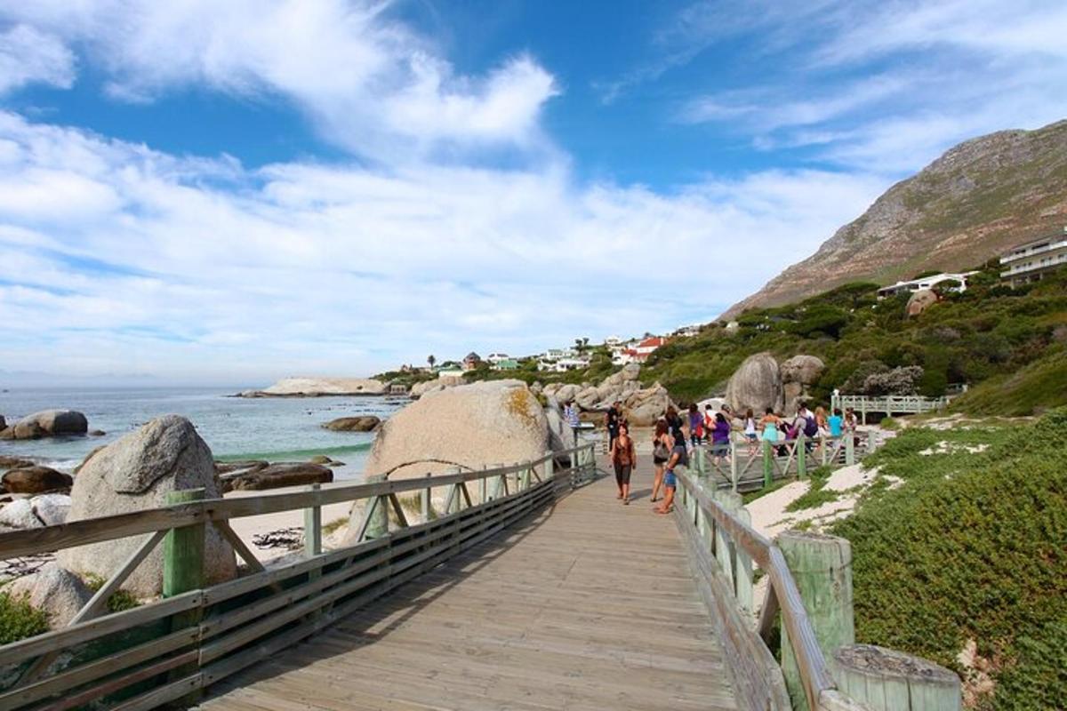 un gruppo di persone che camminano su una passerella sulla spiaggia