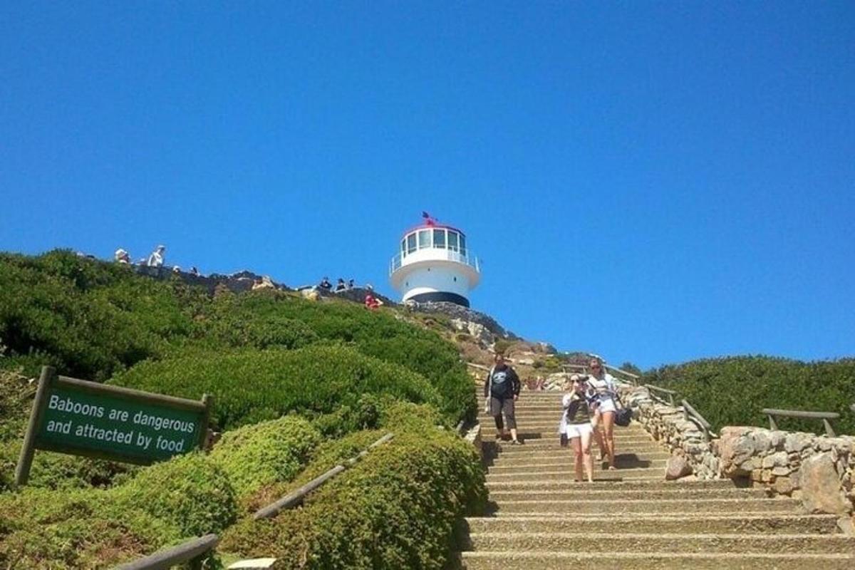un gruppo di persone che sale le scale verso un faro