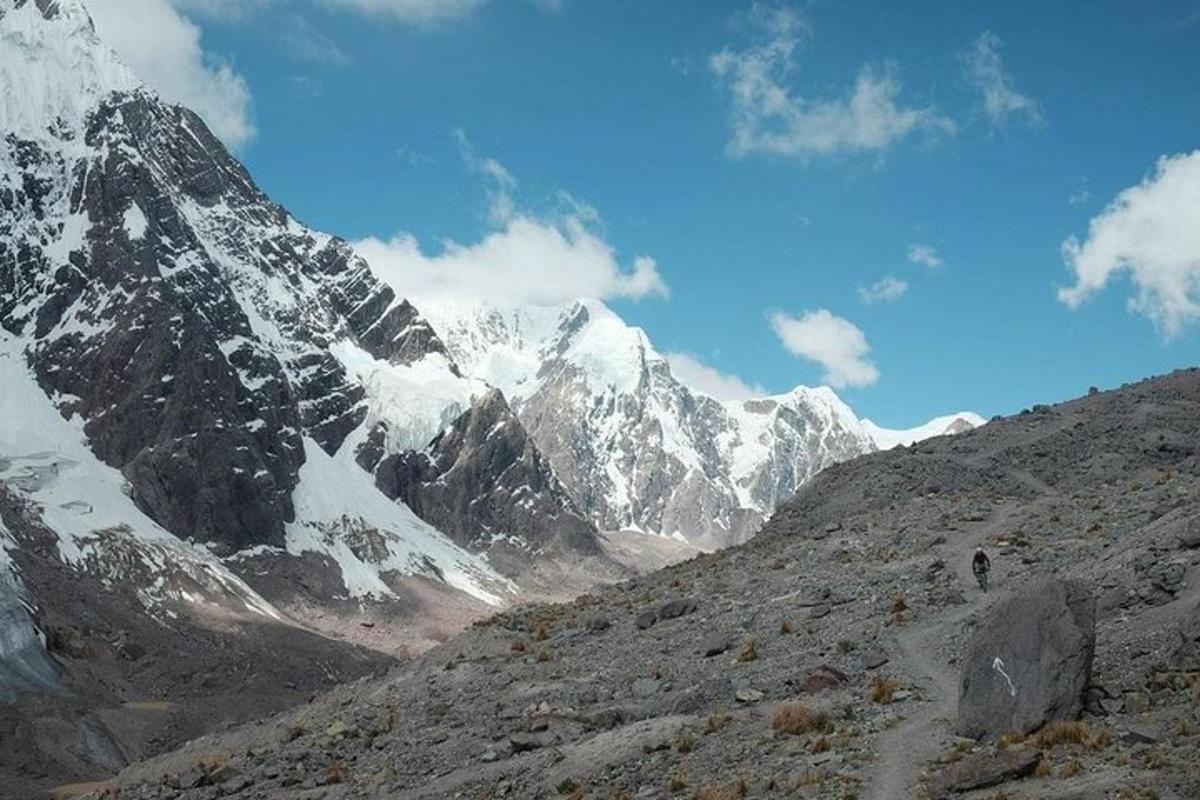 una montagna coperta di neve con una persona che cammina su una collina