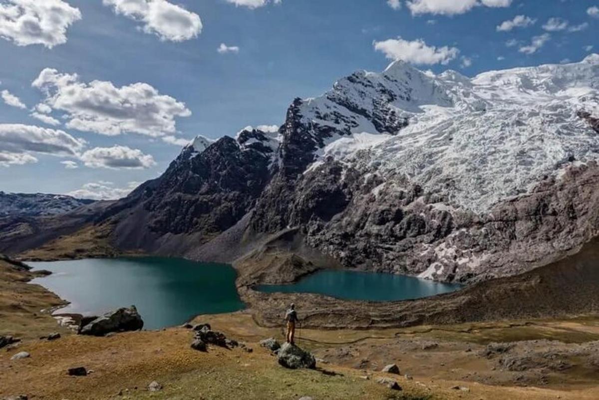 una persona in piedi di fronte a una montagna con un lago