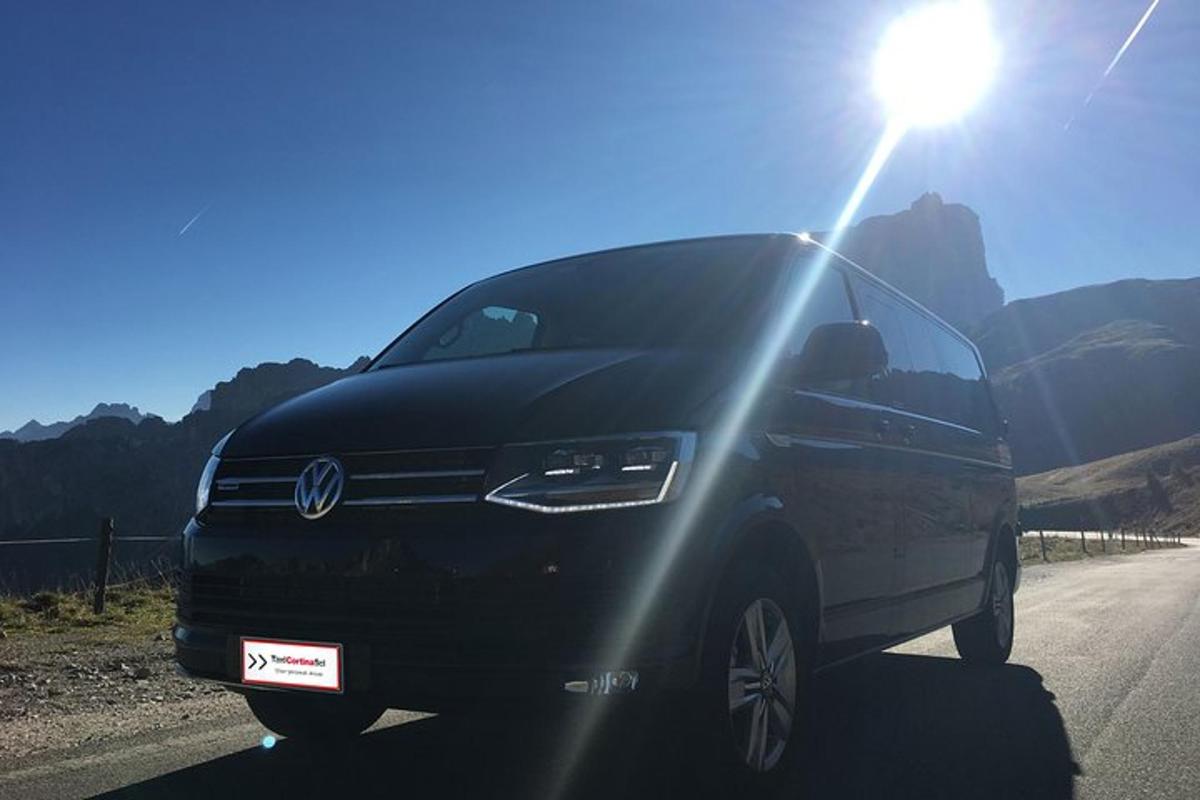 a black van parked on a road with the sun shining