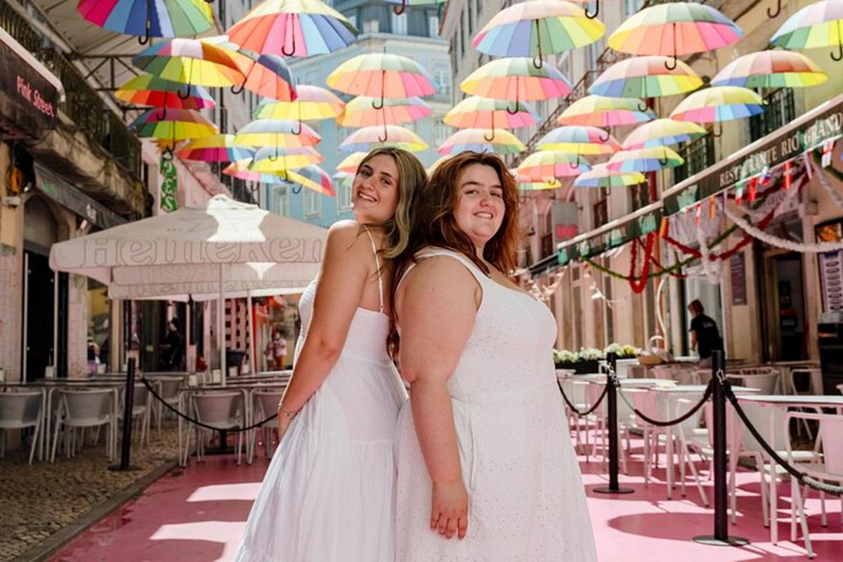 two women in white dresses standing under umbrellas