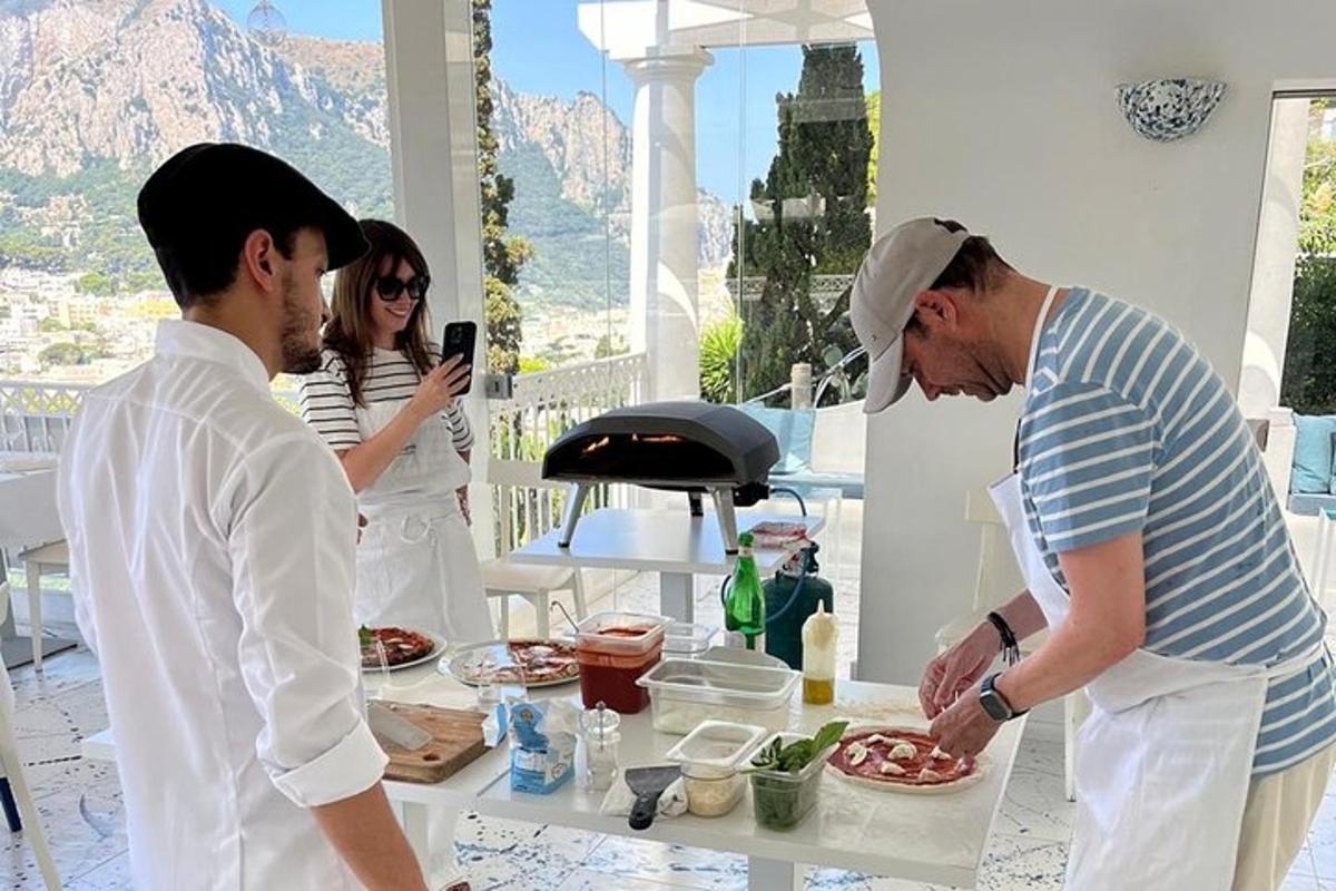 du vyrai stovi prie stalo su lėkšte maisto