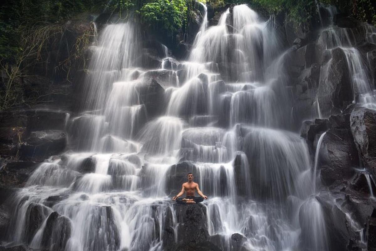 un home assegut davant d'una cascada