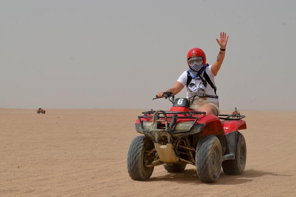 una persona che guida un quad nel deserto