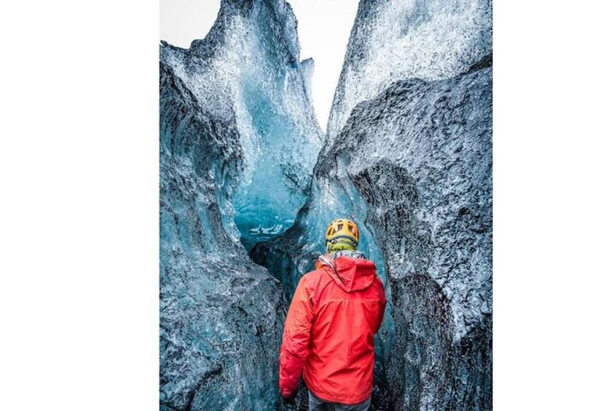 a man is standing in front of a glacier