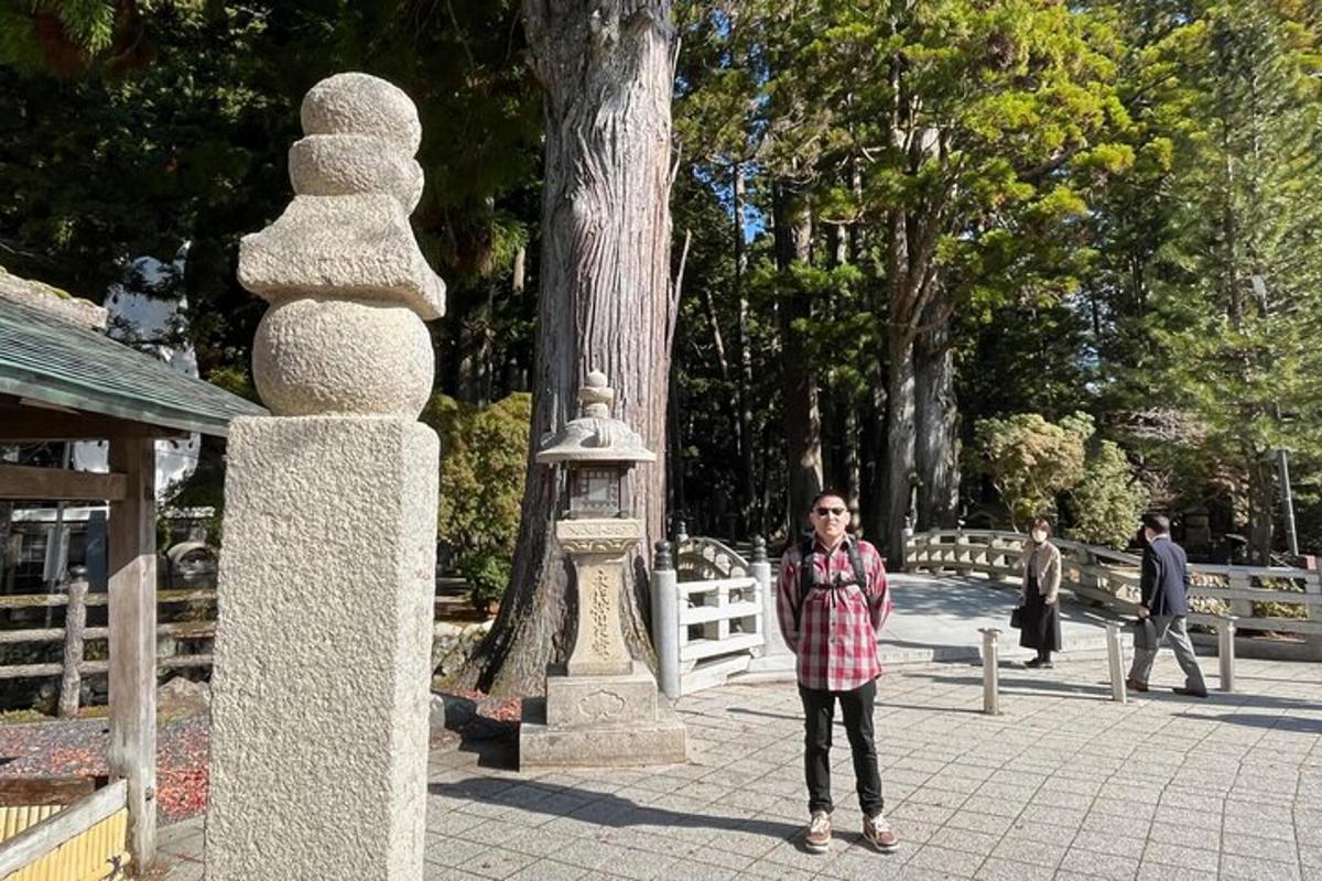 una persona parada junto a una estatua de piedra