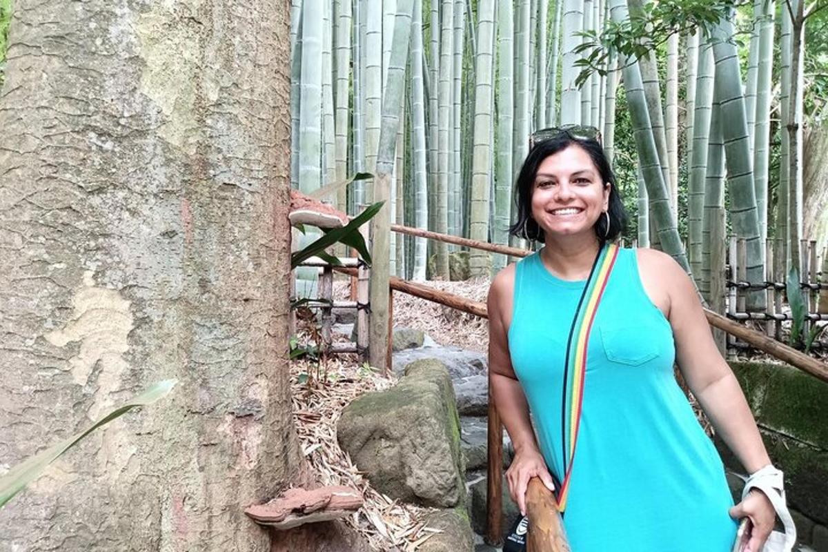 una dona amb un vestit blau dempeus al costat d'un arbre
