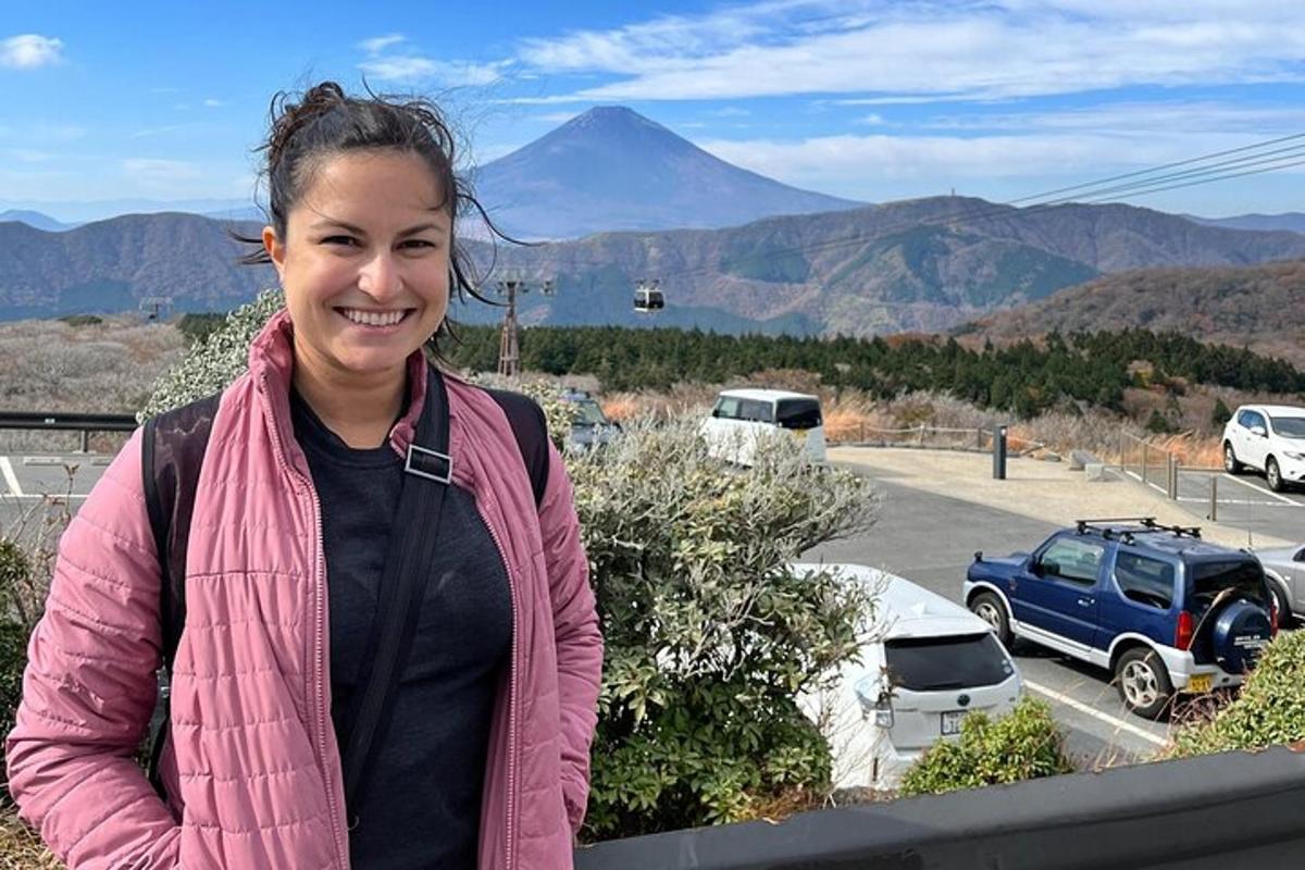 seorang wanita berdiri di balkoni dengan latar belakang gunung