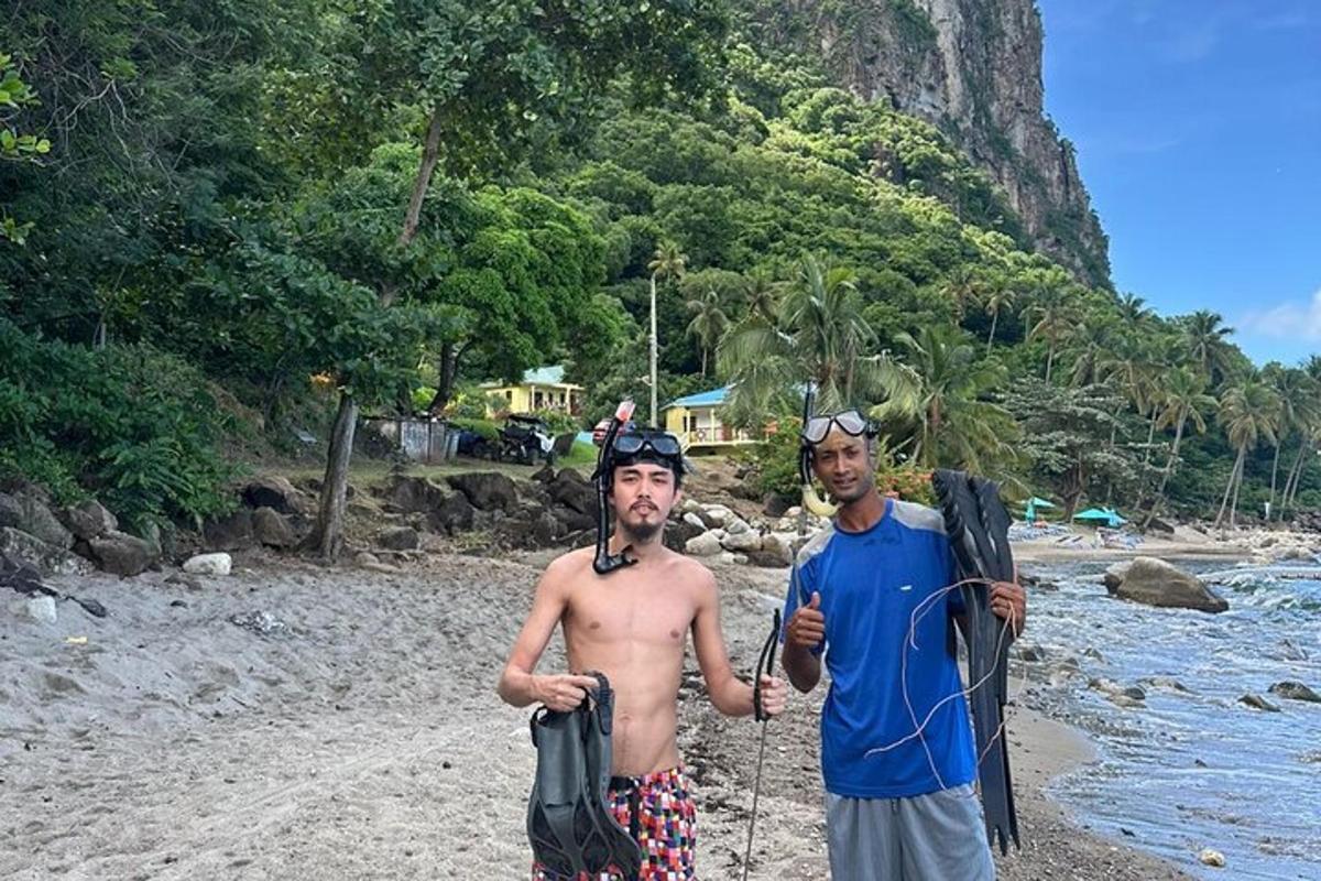 two men standing on a beach with their equipment