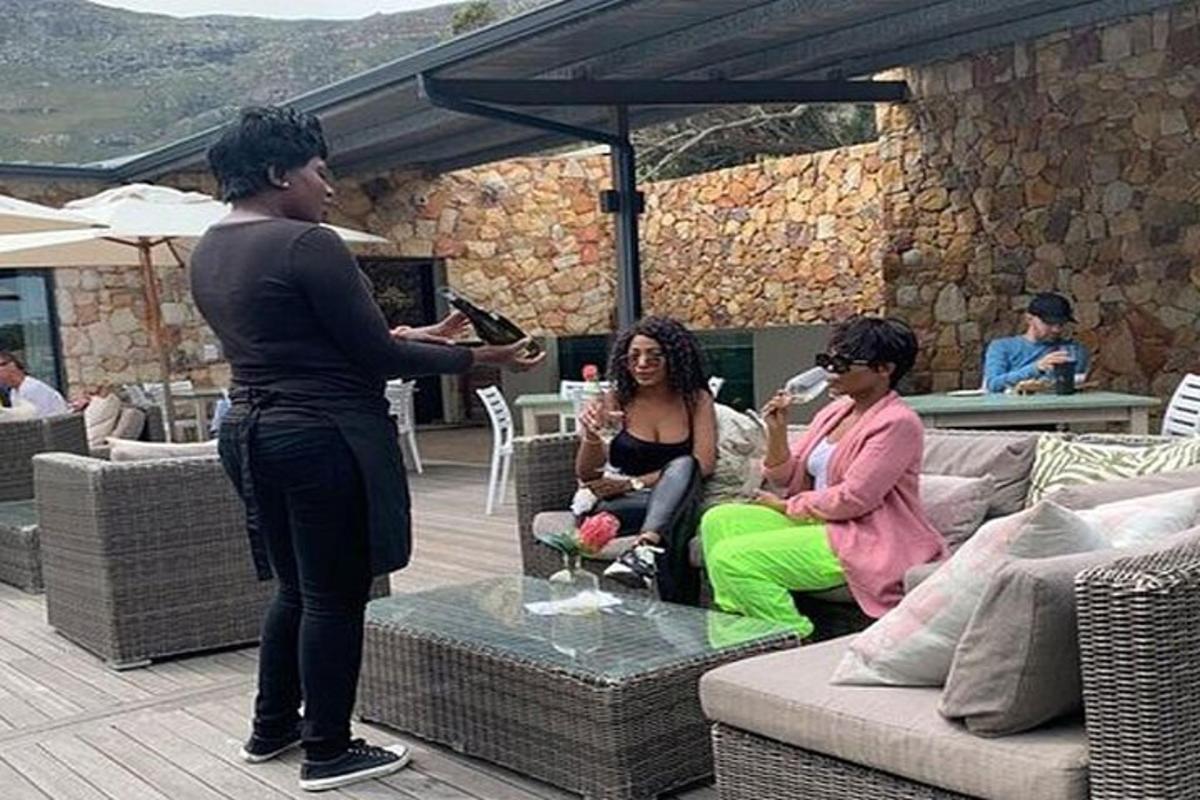 Ein Mann steht mit zwei Frauen auf einer Terrasse