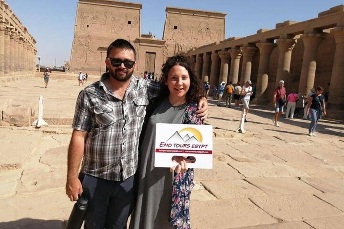 un uomo e una donna che tengono un cartello davanti a un edificio