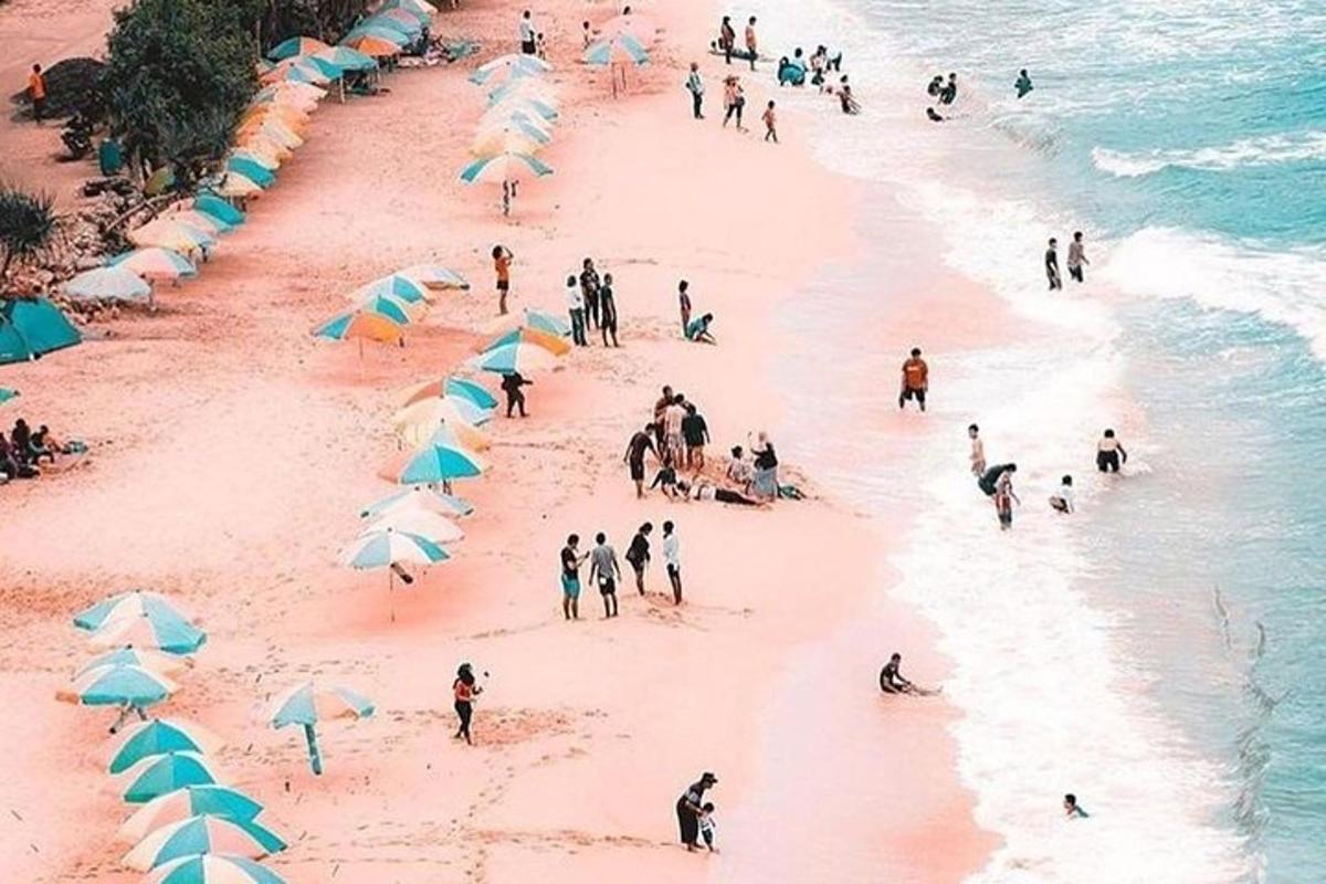 um grupo de pessoas em uma praia com guarda-sóis