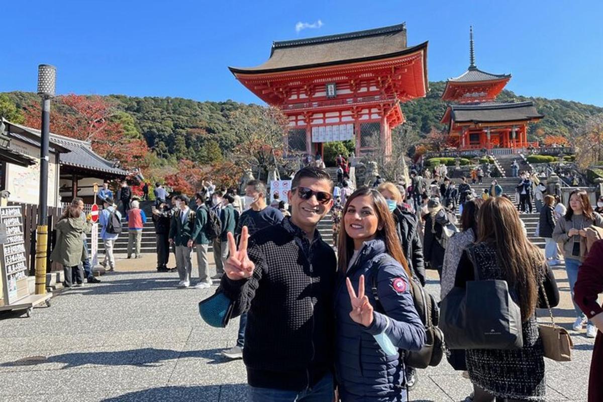 a man and woman giving the peace sign in front of a temple