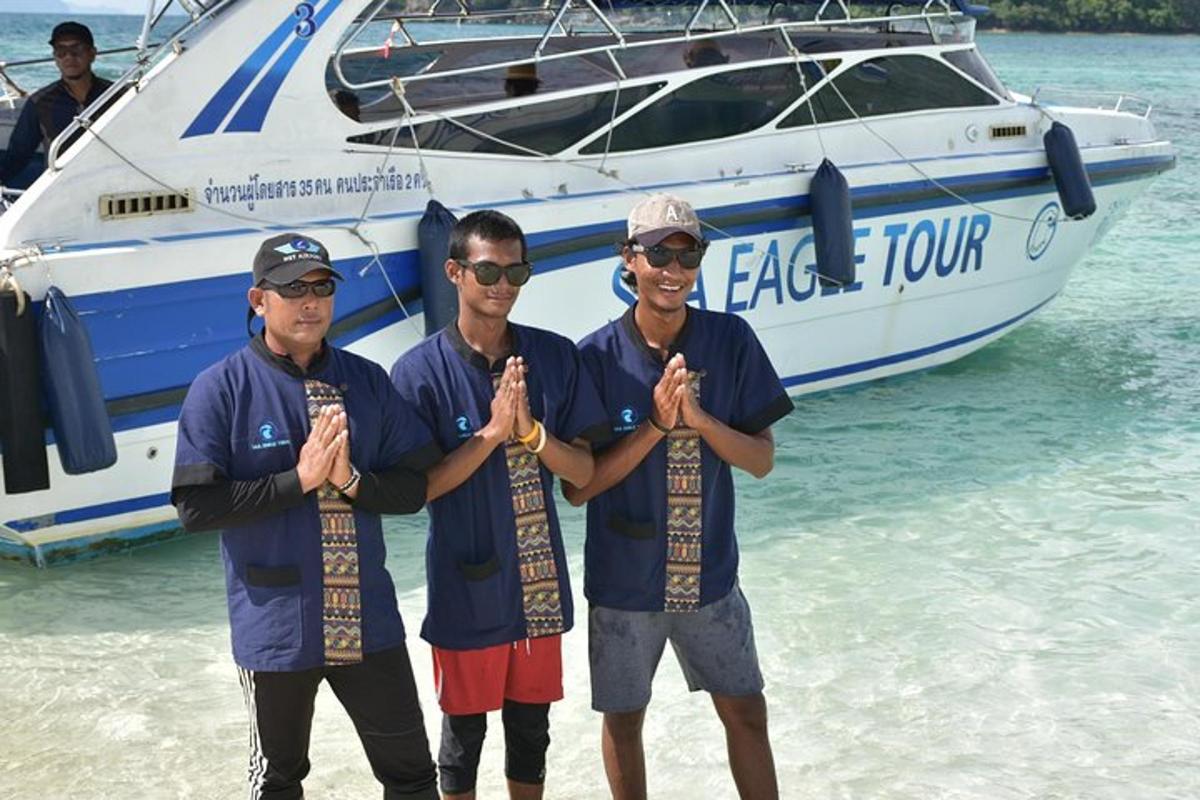 a group of three men standing on a beach with a boat