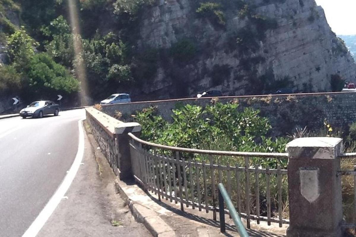 一辆汽车沿着栅栏旁边的道路行驶