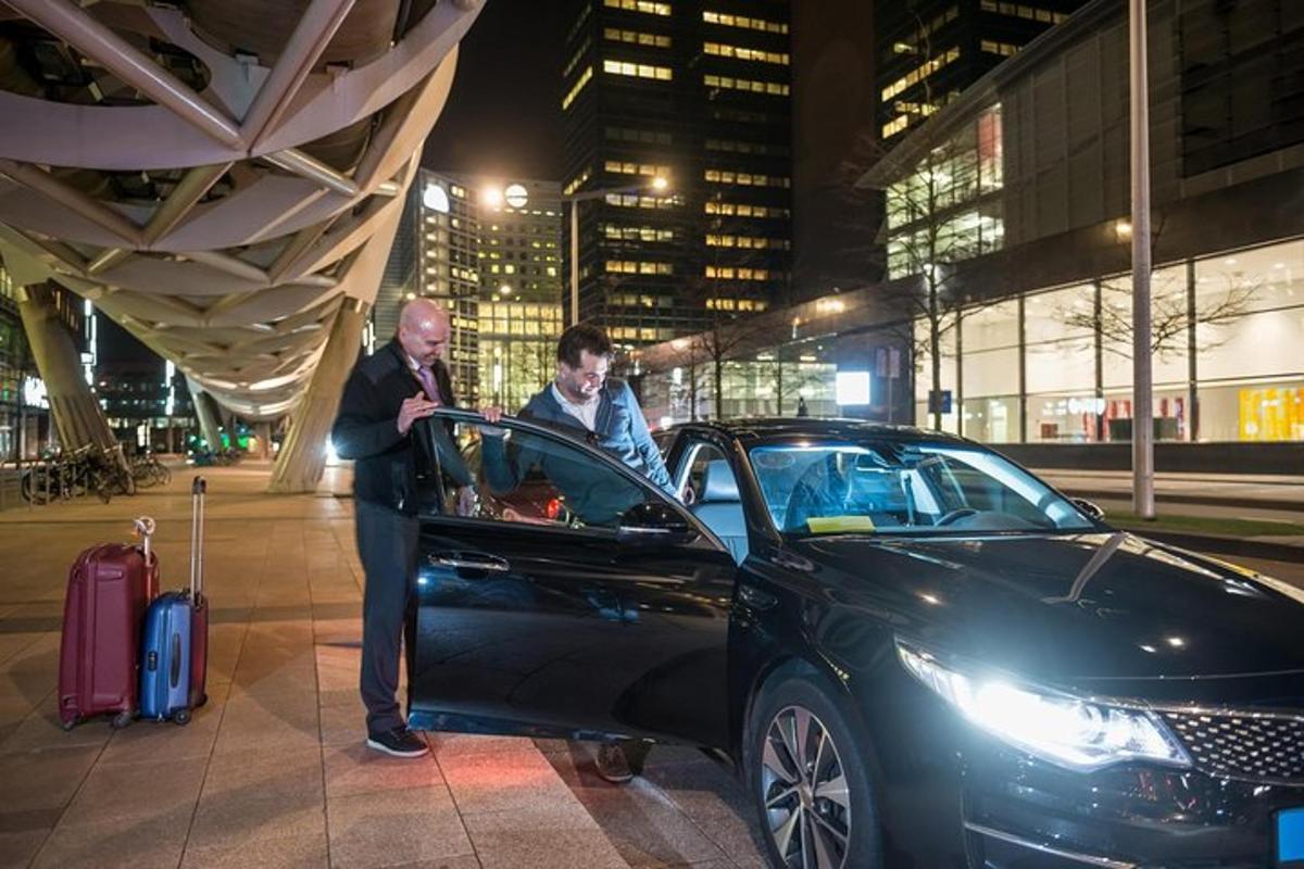 a man is standing next to a black car