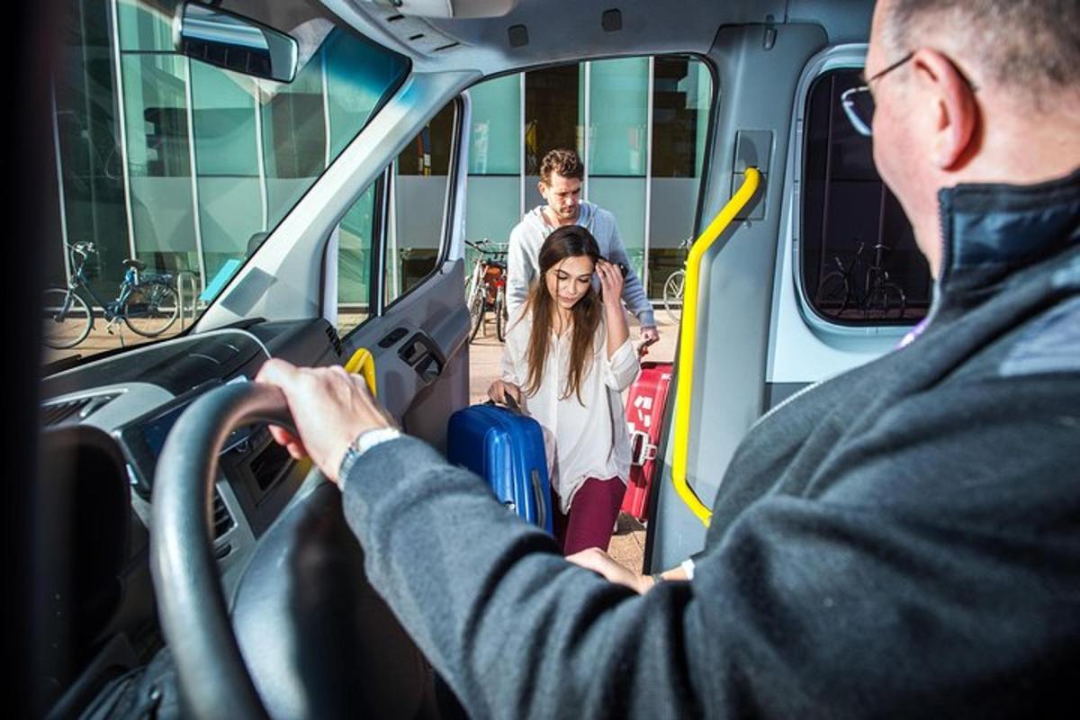 um homem dirigindo um ônibus com uma mulher com bagagem