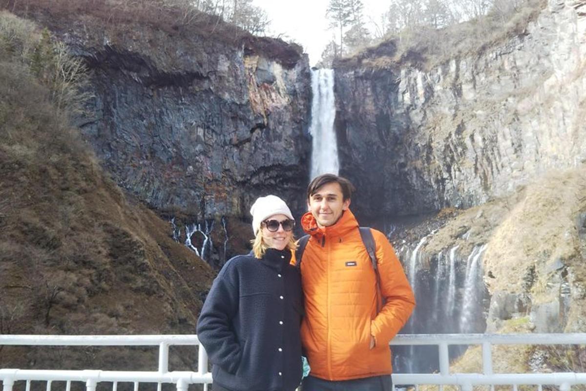 um homem e uma mulher em pé em frente a uma cachoeira