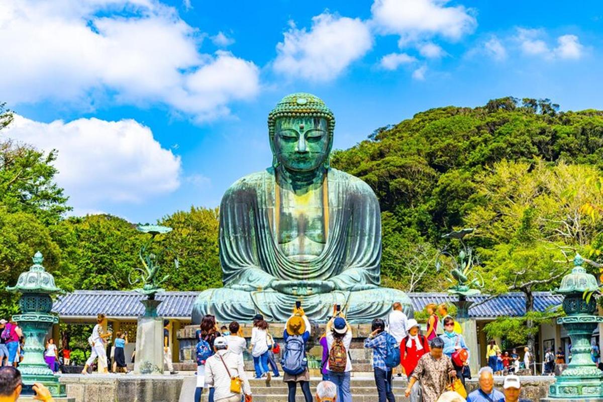 uma multidão de pessoas em pé ao redor de uma grande estátua de Buda