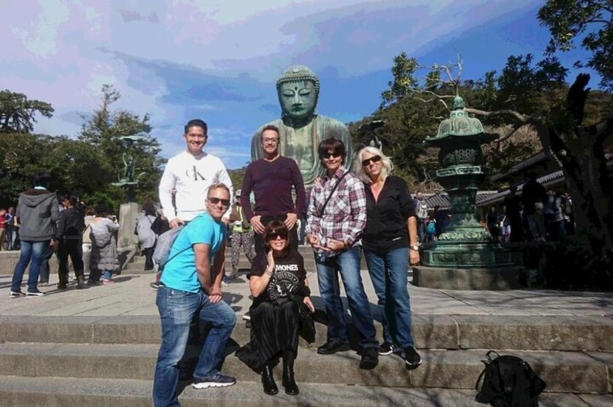 um grupo de pessoas posando em frente a uma estátua