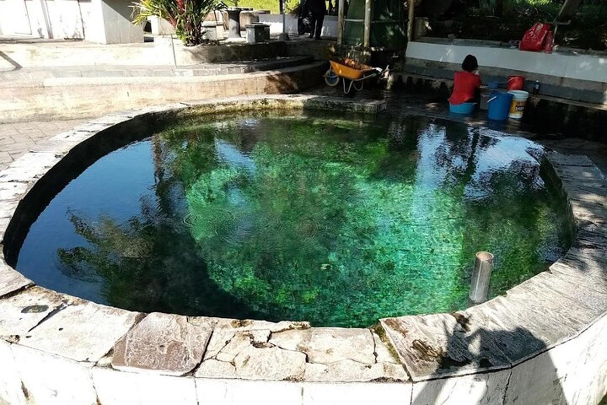 uma pequena piscina de água com uma pessoa sentada nela
