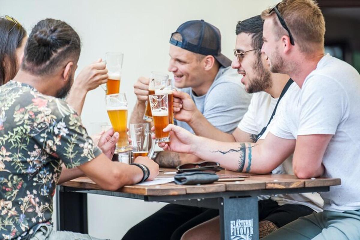 skupina mužů sedících u stolu a pijících pivo