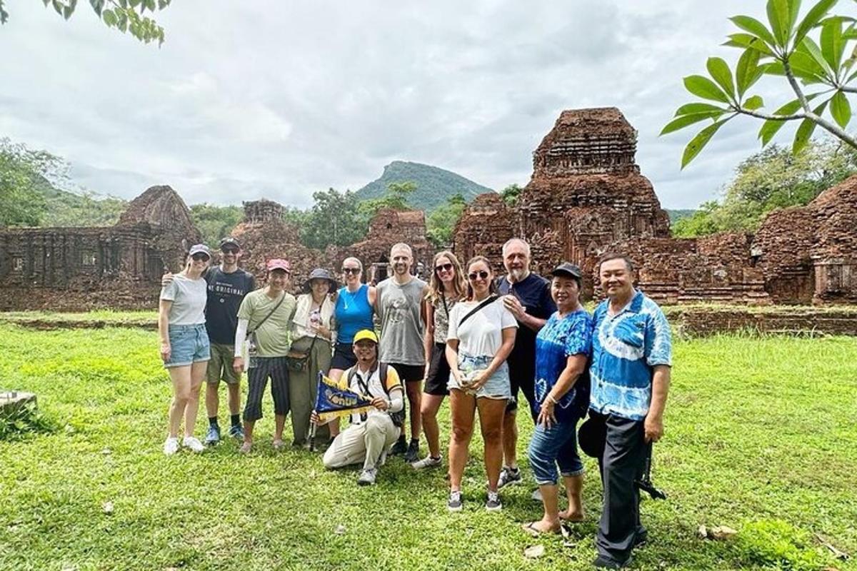 a group of people posing for a picture in front of ruins
