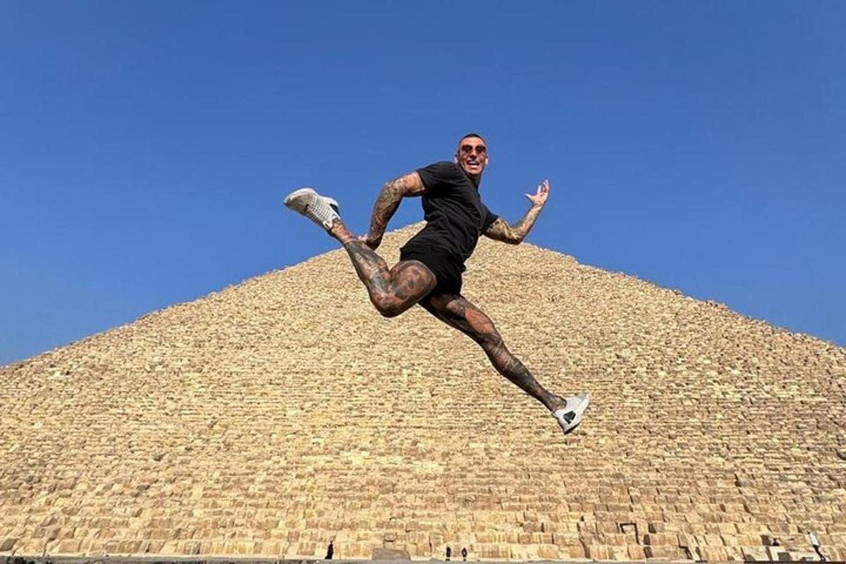 muž skákající do vzduchu před pyramidou