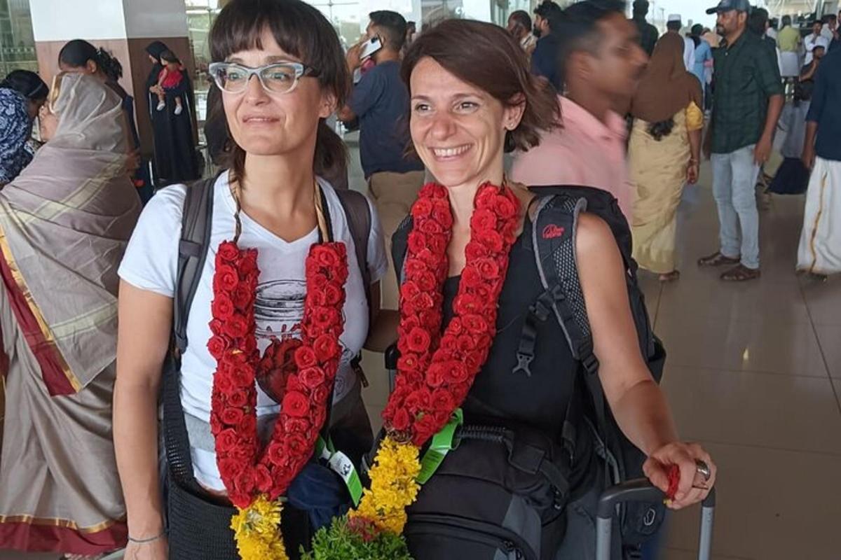 two women are standing next to each other wearing flowers