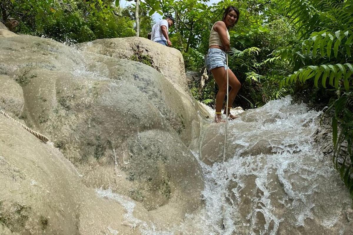 una dona dempeus a la part superior d'una cascada