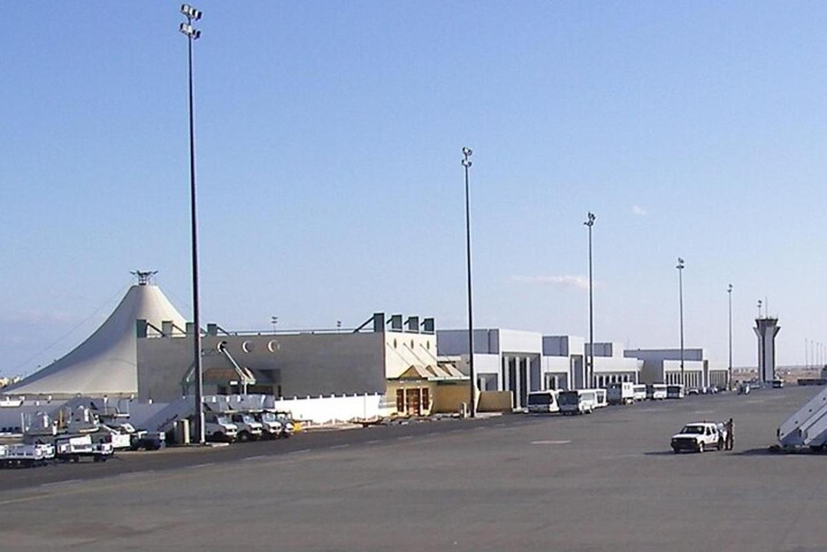 een luchthaven met auto's geparkeerd op een parkeerplaats