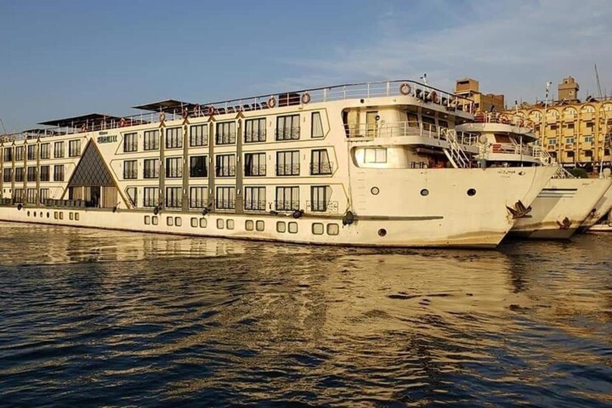 un gran vaixell blanc a l'aigua al costat d'un edifici