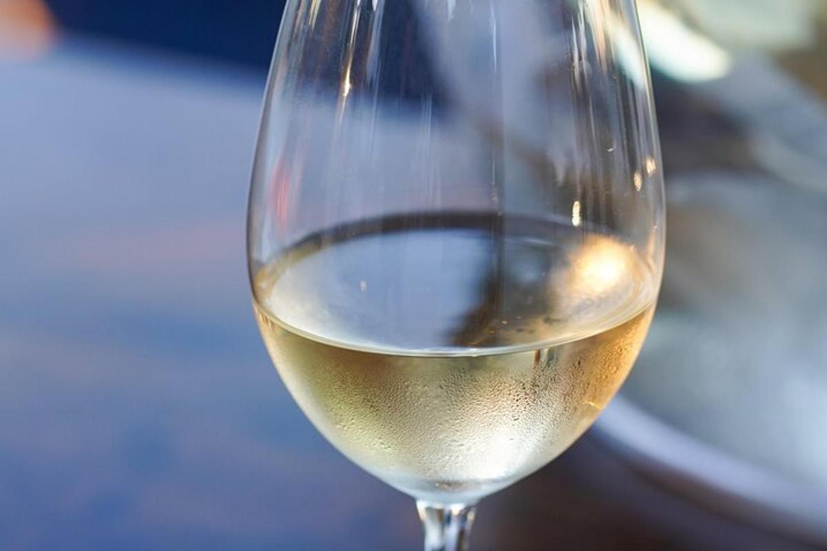una copa de vi blanc asseguda sobre una taula